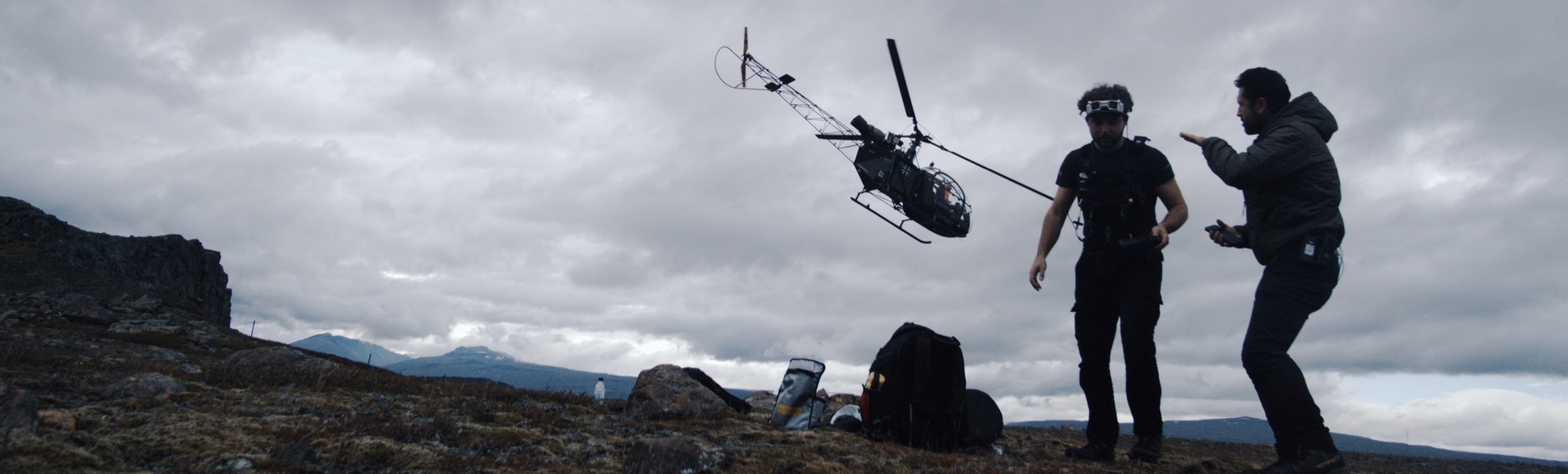 Drone crew on mountain with helicopter